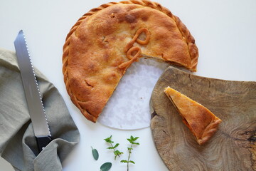 1234567Avanti
Empanada gallega, a delicious Spanish savory pie filled with tender onion, pepper and tomato and octopus, top view