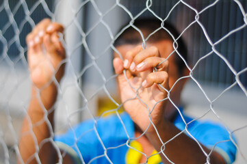 A close-up, soft-focus shot of a person's hands and face blurred behind the sharp focus of a...