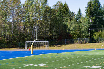 A football and a soccer goal in a sport field