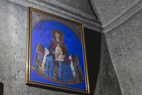 View of a framed Madonna and Child icon mounted on a rough stone wall, bathed in soft light and shadow, Geghard Monastery, Mets Gilanlar, Ararat Province, Armenia.