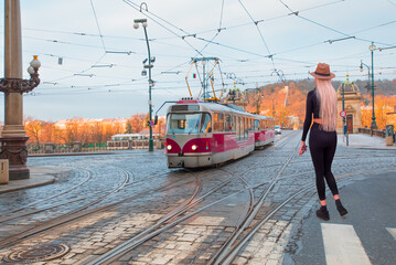 Red tram passing on  Bridge and famous Prague Castle on the background in Prague, Czech Republic.