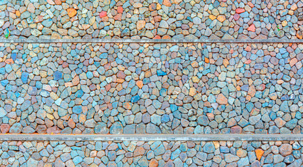 Colorful background texture of natural stone.- Texture of a colorful rounded stone wall