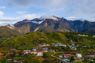 Aerial view of Mount Kinabalu surrounded by lush green hills and valleys in Sabah, Malaysia. Scenic...