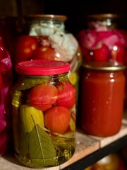 Large glass jars filled with assorted homemade pickles and vegetables. Food blogs, organic lifestyle, farm market, and traditional cuisine