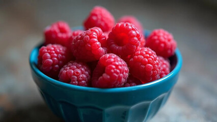 Fresh raspberries in a blue bowl. 