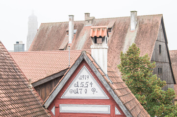 Ausblick von umlaufender Stadtmauer auf die historische Altstadt von Nördlingen mit Fachwerkhaus Ackerbürgerhaus und Kirchturm Daniel der St. Georgskirche im Nebel