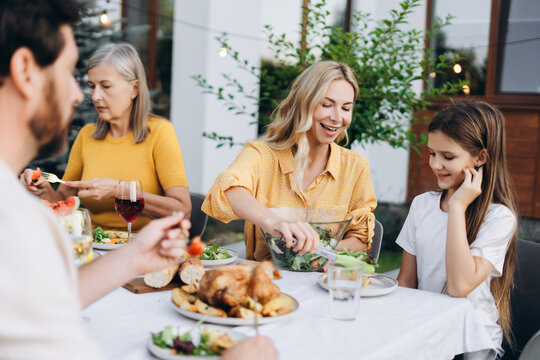 Happy family enjoying dinner together in the garden, thanksgiving day concept