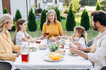 Happy family enjoying outdoor meal in backyard garden