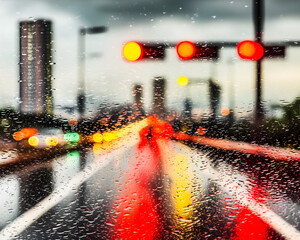 Rainy City Street View with Blurred Traffic Lights and Reflection