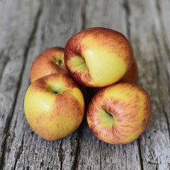 Image of five braeburn apples on rustic wooden background.