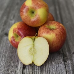 Image of five braeburn apples on rustic wooden background.