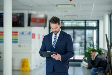 Obraz premium Business professional standing with tablet in hand, ready for presentation