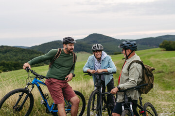 Fototapeta premium Grandfather, father and teen boy on cycling trip taking selfie.