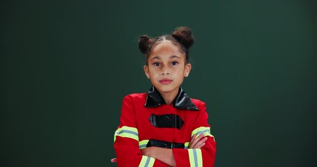 Little girl, face and costume in studio with mockup or green background for halloween, cosplay and dress up for party. Child, serious and confident for career day at school in fire fighter outfit.