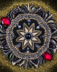 Intricate Mandala Design with Gems and Beads on Shimmering Background