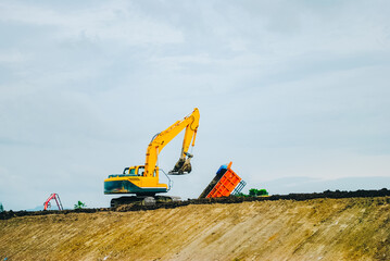 Excavator on limestone mountain. Backhoe digging sand, soil on limestone mountain, Heavy construction equipment is digging at construction site. Excavator is working on soil, foundation. Road construc