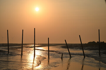 The golden out of the sea under the morning sun and fishing people