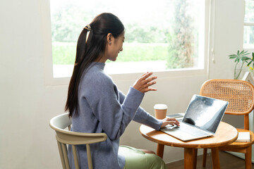 Young Asian woman enjoying a peaceful moment reading a book near window. Calm lifestyle, self-learning, and mindfulness at home.