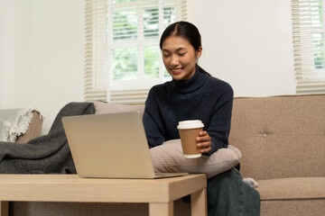 Young Asian woman enjoying a peaceful moment reading a book near window. Calm lifestyle, self-learning, and mindfulness at home.