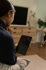 Young Asian woman enjoying a peaceful moment reading a book near window. Calm lifestyle, self-learning, and mindfulness at home.