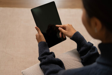 Young Asian woman enjoying a peaceful moment reading a book near window. Calm lifestyle, self-learning, and mindfulness at home.