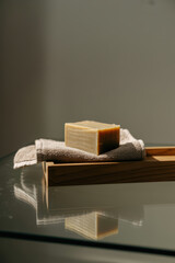 Elegant Handmade Soap on Soft Woven Towel with Serene Reflection in Warm Ambient Light
