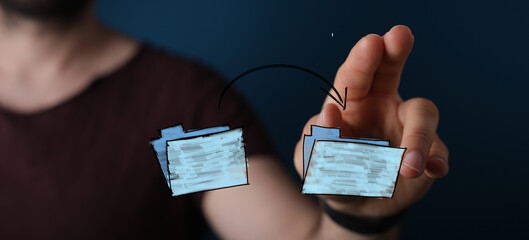 Hand moves files between folders.  Data transfer, online storage, cloud computing concept.