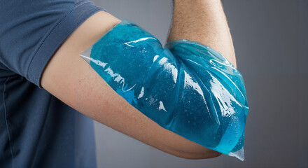 Man applying cold pack to elbow to relieve pain and swelling  