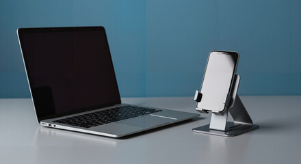 Modern laptop and smartphone stand on minimalist workspace table  