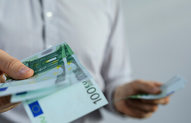 Close-up of hands exchanging euro banknotes.  Perfect for finance, business, and wealth concepts.