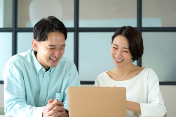 Obraz premium オフィスで仕事をする日本人男女