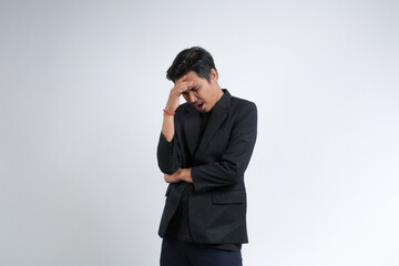 An Asian businessman wearing a blazer with a confused expression. Studio shot with white background.	