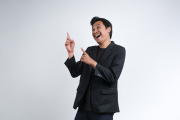 An Asian businessman wearing a blazer raising both hands with a cheerful shrugging expression, smiling confidently. Studio shot with white background.	