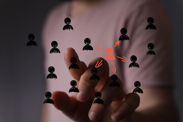 Hand points to a central figure in a network of people, symbolizing leadership, influence, or team...