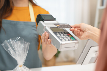 Obraz na płótnie Canvas Cashless payment in shopping concept, Close-up hands using credit card pay at cafe.