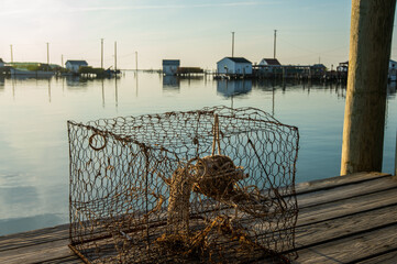 chesapeake bay style crab pot with fishing shanties in the background.