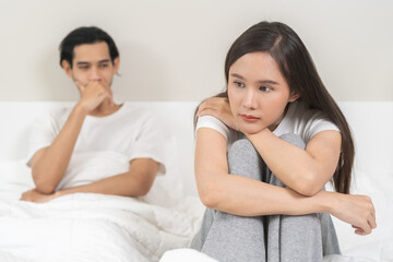 Angry, depressed, frustrated asian couple quarrel, fighting on bed in conflict, divorce or relationship problem, stress from marriage, fight and argument, unhappy married couple and sexual impotent.