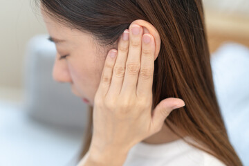 ear problem concept, Young woman touching her ear feel pain from inflammation.