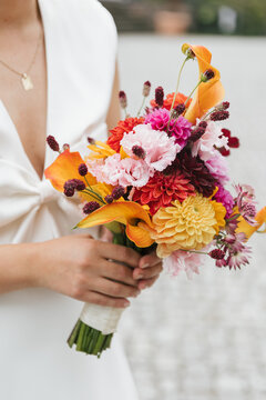 moden bride holding bouquet of colorful flowers (mostly pink and orange)
