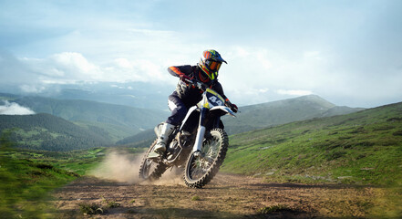 Naklejka premium Bright collage. Professional biker in helmet speeds on mountain trail with dust and panoramic 3 D rendered background of green hills. Concept of motorsport, speed, travel, adventure.