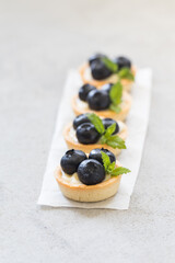 Vegan dessert. Mini round Blueberry tartlets. Light background. Close up