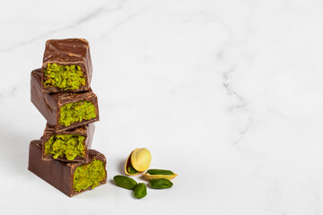 Vegan Dubai chocolate candy with crispy kataifi and pistachio paste. Close up. White background. Copy space