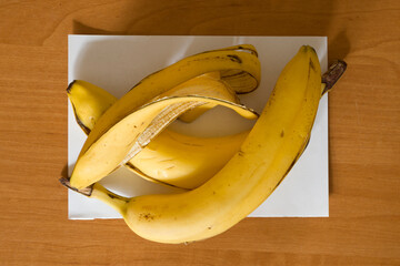 Banana peel is located on a white paper.