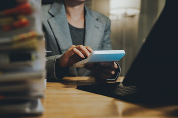 A person organizing a large stack of documents with binder clips on an office desk, representing...