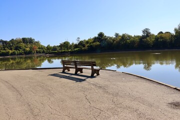 The empty wood bench at the lake in the park.