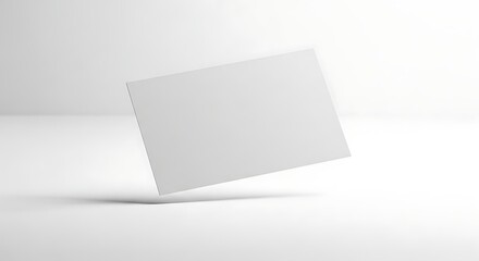 Naklejka premium A blank white business card is shown floating in a minimalist studio setting.