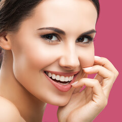 Studio face portrait of happy cheerful beautiful young woman, isolated against red background. Brunette hair brightly teeth smile girl. Dental care, dent concept. Square image