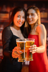 Friends having fun clinking glasses with beer