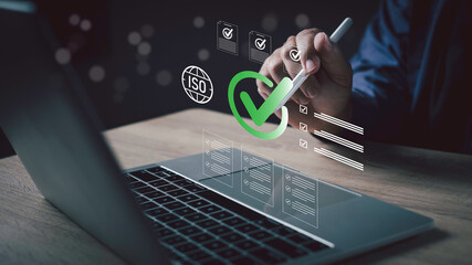 Businessman using laptop with digital ISO certification checklist interface, symbolizing quality assurance, compliance standards, process management, and business certification.