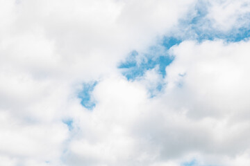 Soft white clouds contrast against a bright blue sky during a calm afternoon